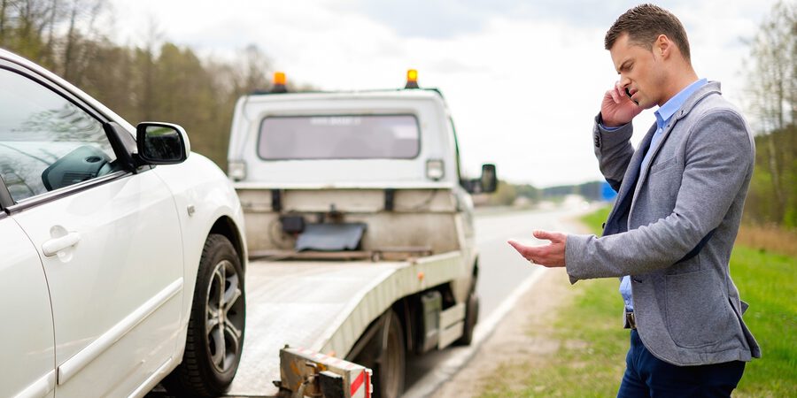 man calling beside his car