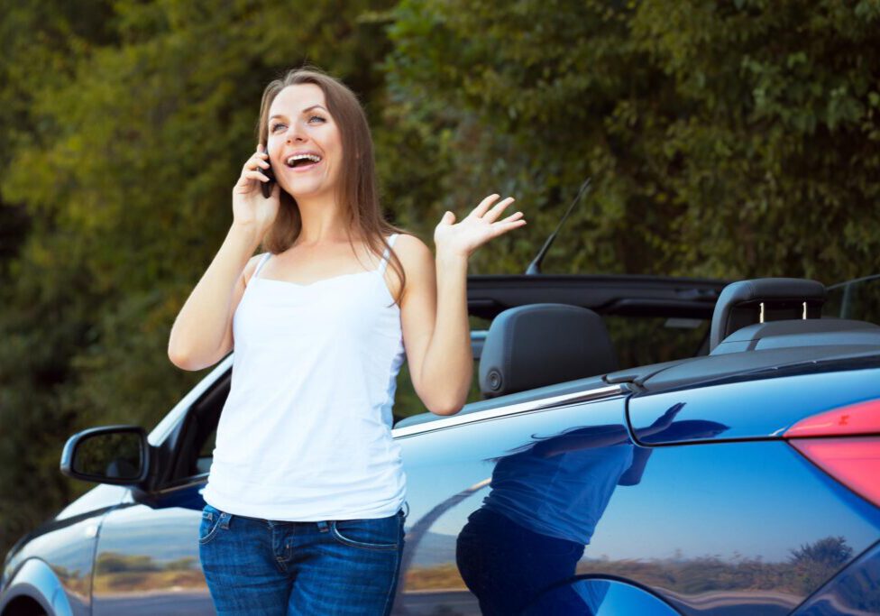 woman calling beside her car