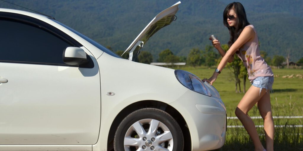 woman standing beside her car